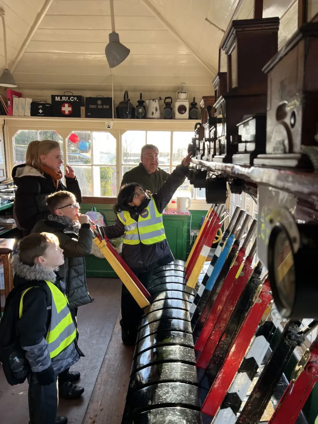 School pupils pulling levers in historic signal box