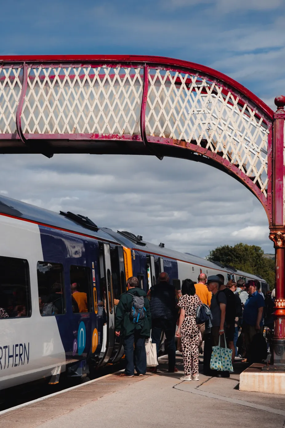 Passsengers getting onto a northern train under bridge
