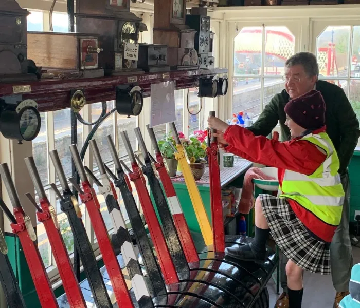 Signal box with two people pulling on the levers