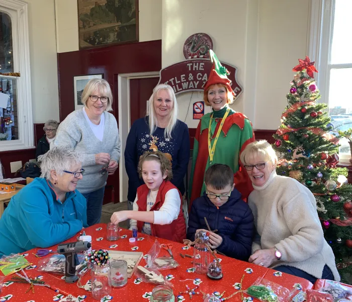 Elf, 4 women and two children making festive crafts