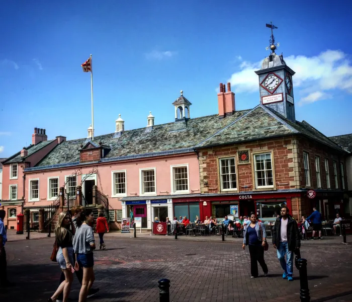 A toen hall building eith clock and shoppers