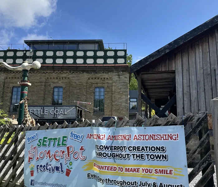 Railway water tower and poster promoting Settle Flower Pot festival
