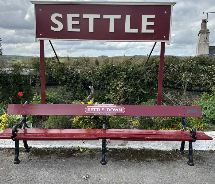 Railway sign and bench with the name Settle.