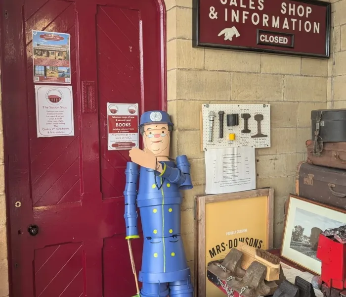 A Midland Station with a character  Northern Guard made out of plant pots,