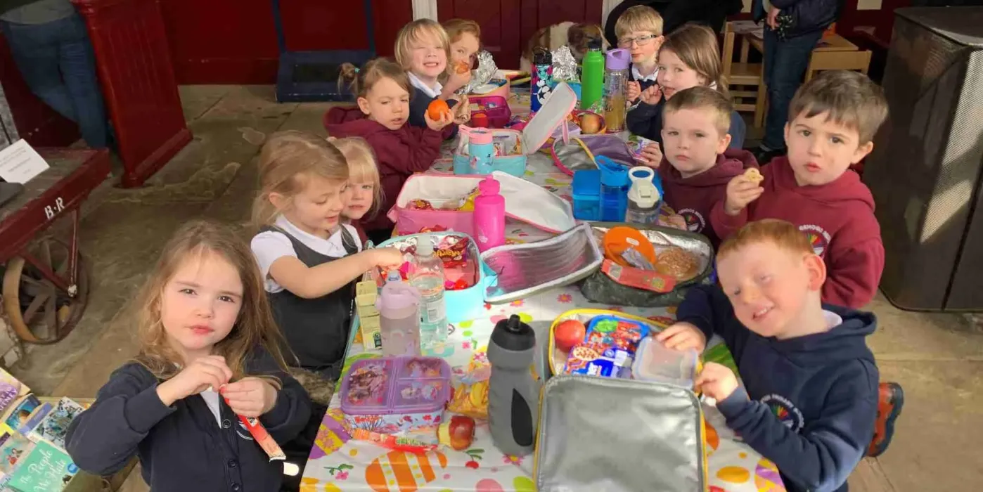 12 school children sit around craft table in Appleby Station