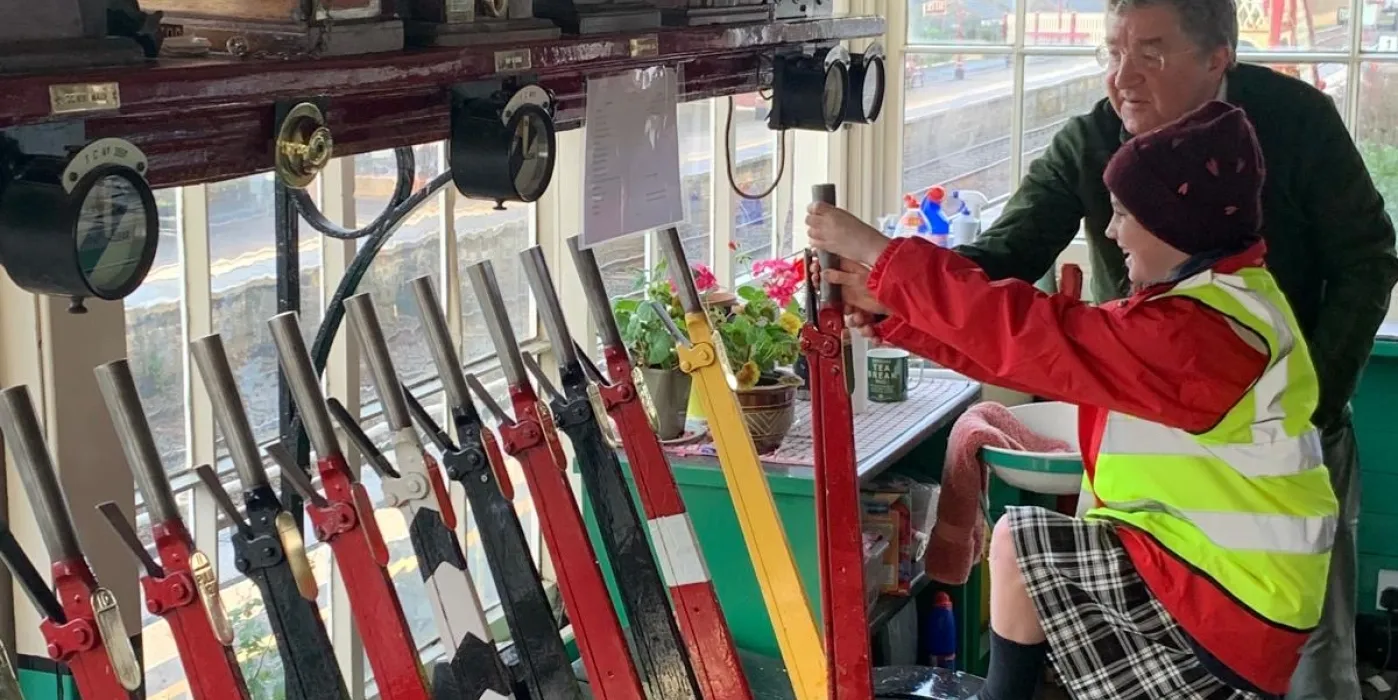 Signal box with two people pulling on the levers