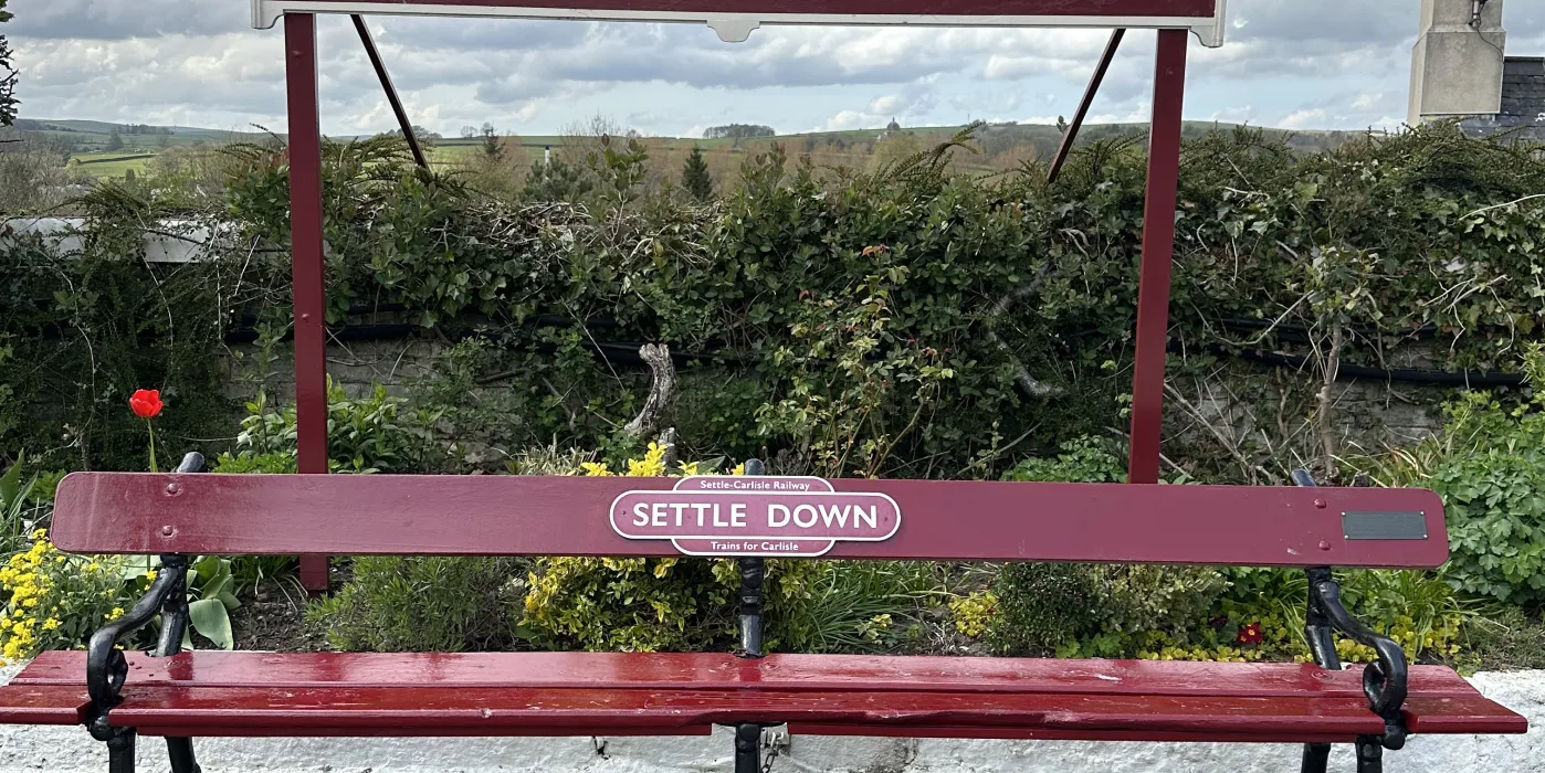 Railway sign and bench with the name Settle.